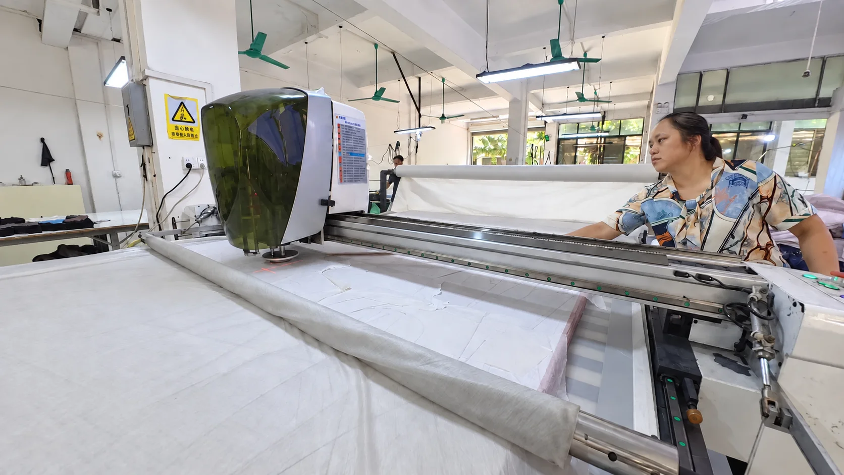 Cutting machine processing fabric panels on the factory floor