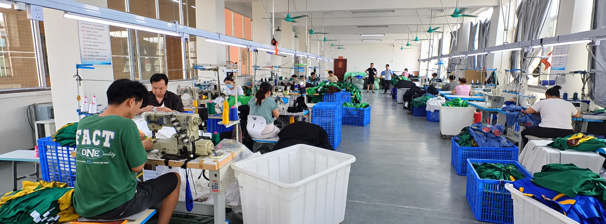 Jiashun sewing floor with workers, sewing machines and garment bins along the central aisle