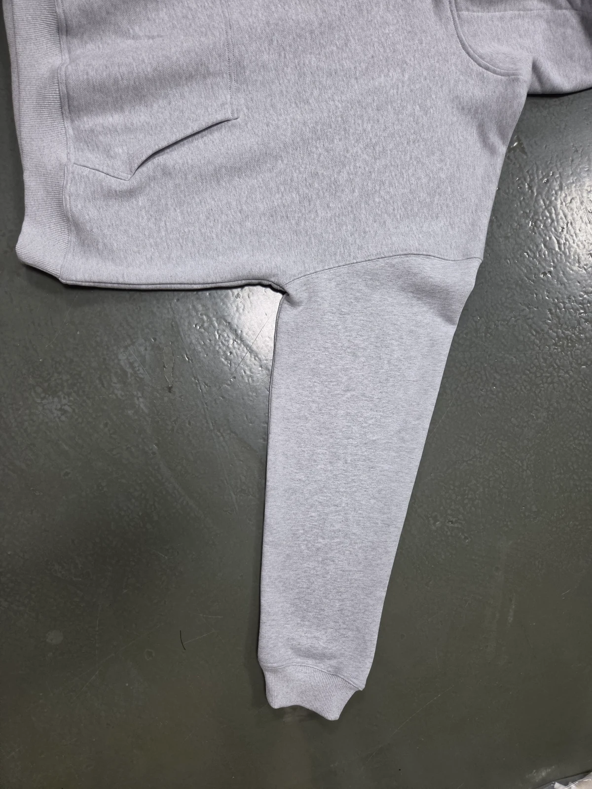 Hem, pocket and sleeve seams on a grey hoodie sample