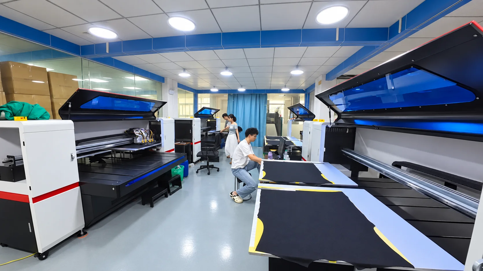 Workers preparing fabric panels beside printing equipment at Jiashun